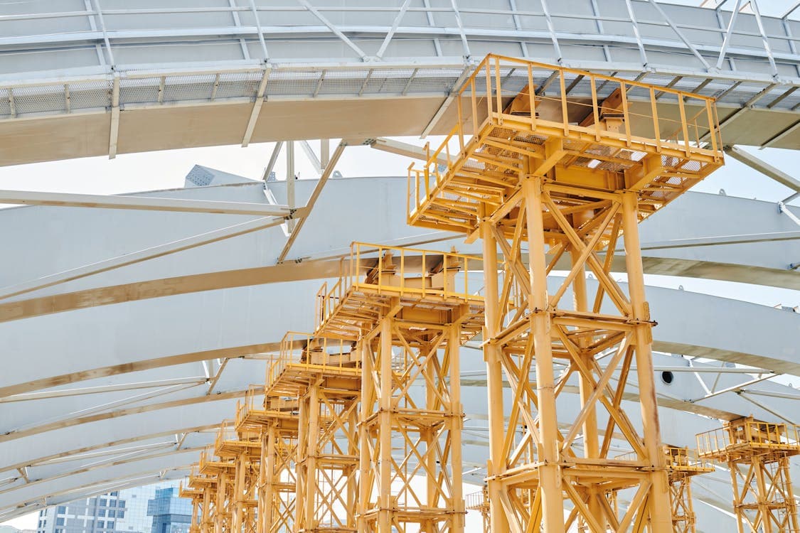 Yellow metal scaffolding beneath steel arches